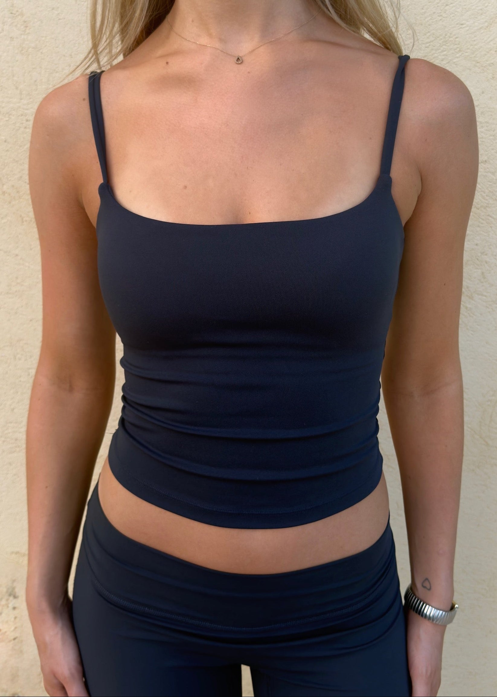 Model is wearing sculpt top in dark blue